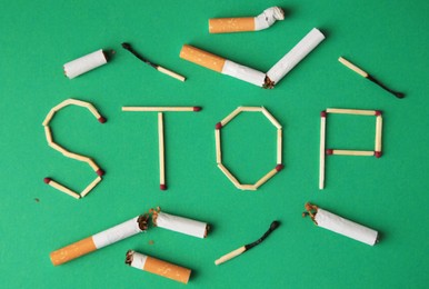 Photo of Word Stop made of matches and cigarette stubs on green background, flat lay. Stop smoking concept