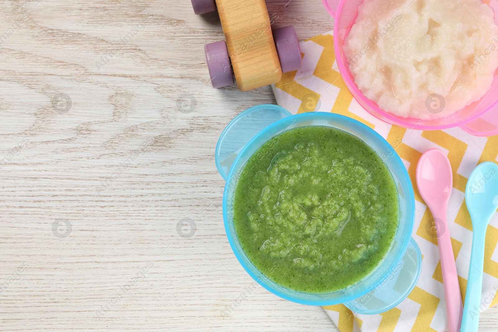 Photo of Healthy baby food. Different tasty puree in bowls on white wooden table, flat lay with space for text