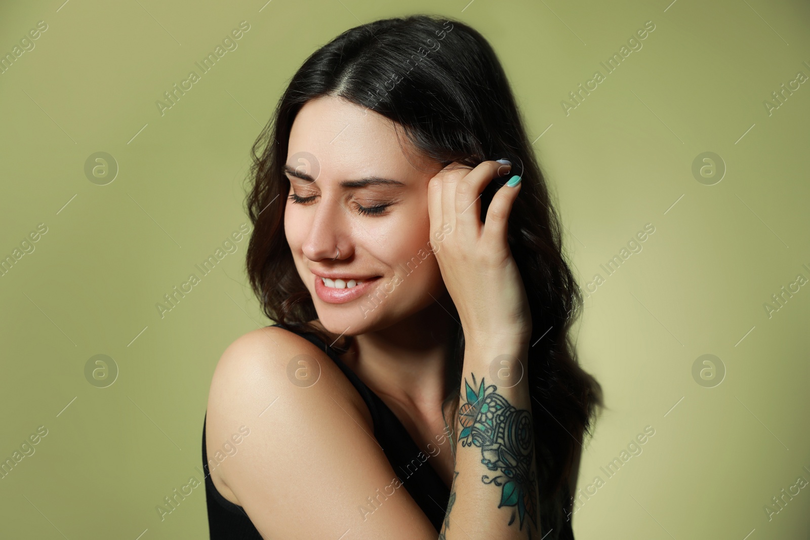 Photo of Beautiful young woman with nose piercing on green background