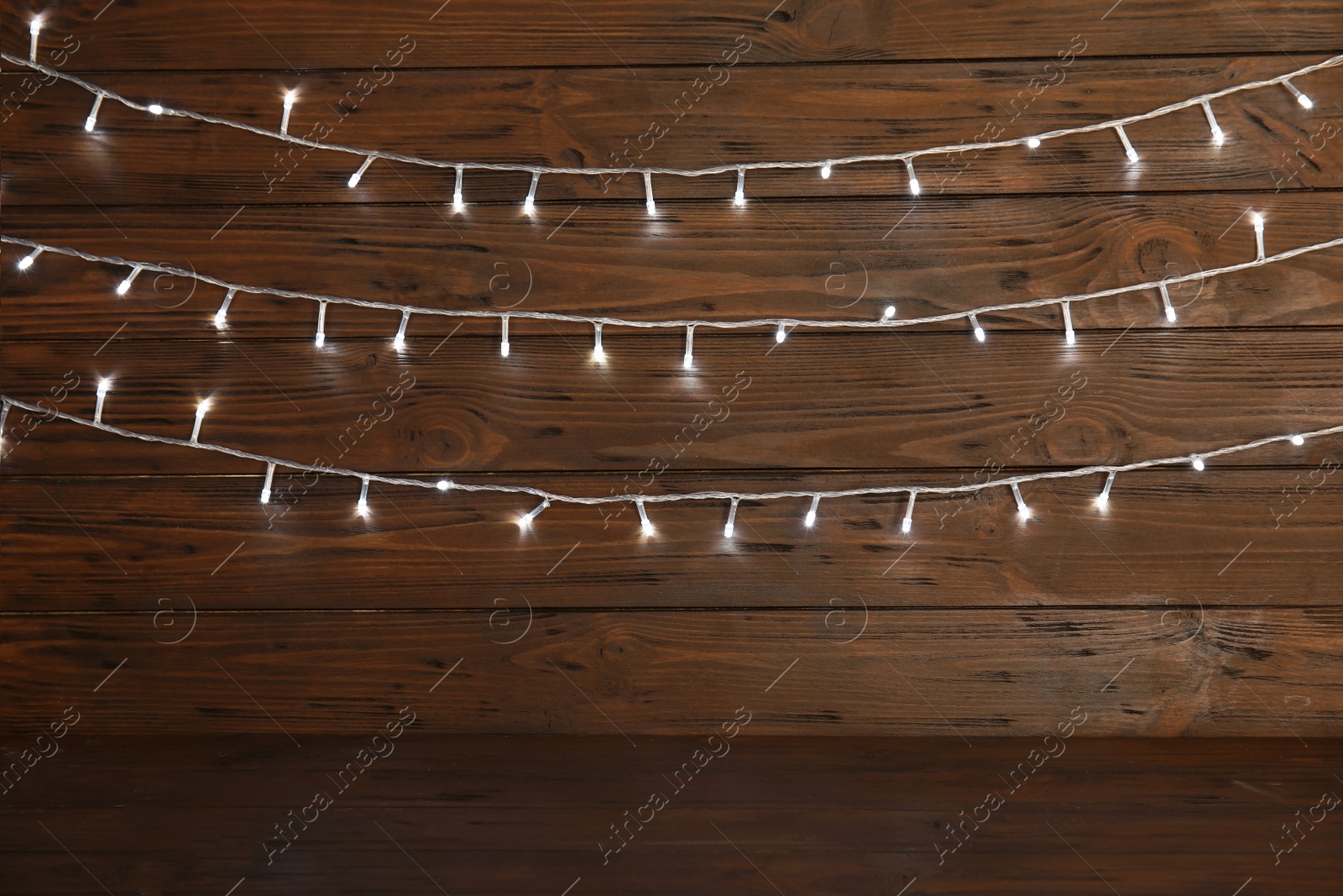 Photo of Beautiful Christmas lights on wooden background