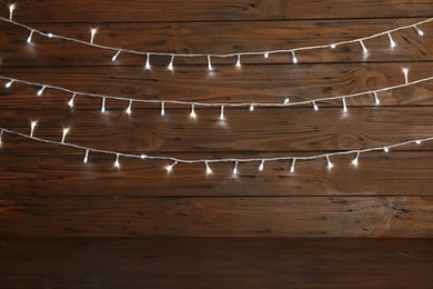 Photo of Beautiful Christmas lights on wooden background