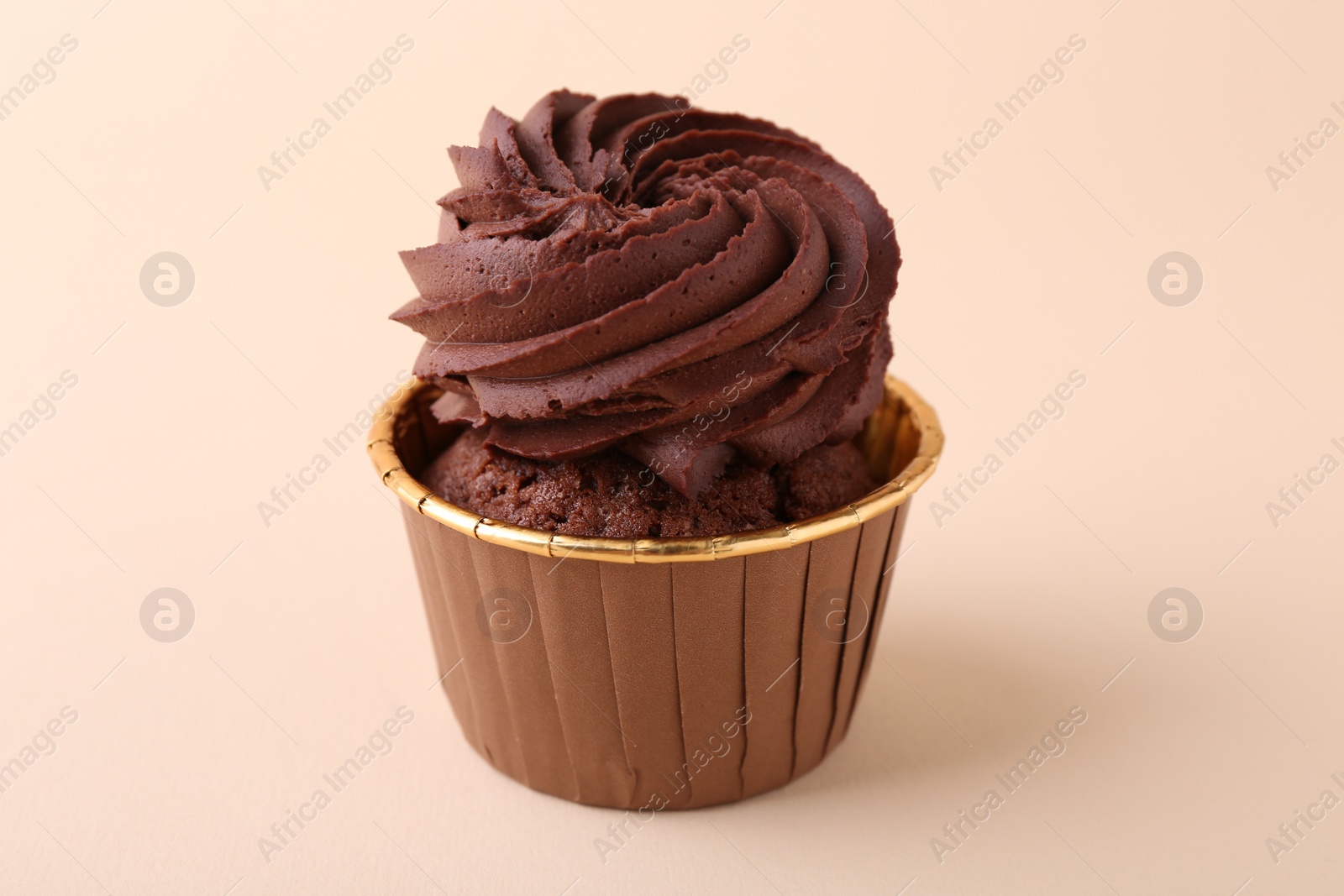 Photo of Delicious chocolate cupcake on beige background, closeup