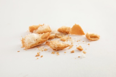 Photo of Scattered bread crumbs on white background, closeup