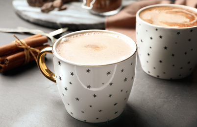 Photo of Cups of delicious hot cocoa on grey table