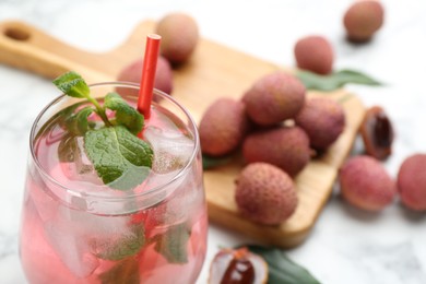 Photo of Delicious lychee cocktail with mint in glass on table, closeup. Space for text