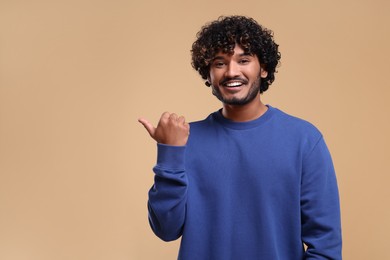 Handsome smiling man on beige background, space for text