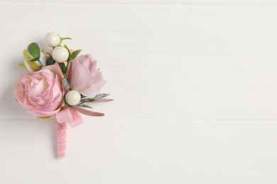 Photo of Beautiful boutonniere on white background, top view. Space for text