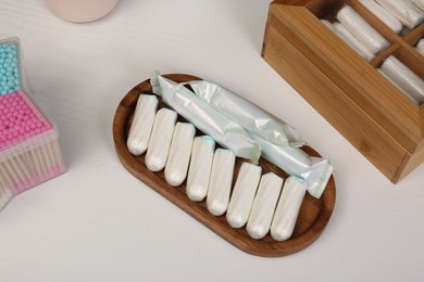 Photo of Many different tampons on white table, above view. Menstrual hygienic product
