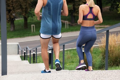 Healthy lifestyle. Couple running down stairs outdoors, closeup