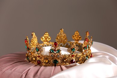 Beautiful gold tiara with gems on pink and white cloth