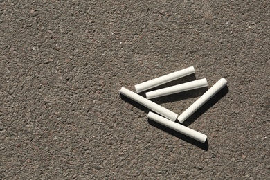 Photo of White chalk sticks on asphalt, top view
