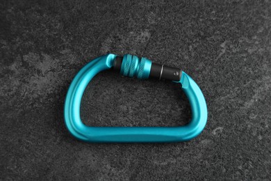 Photo of One metal carabiner on black table, top view