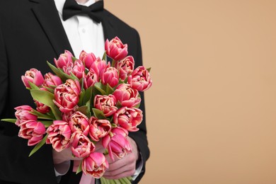 Photo of Man with beautiful bouquet on beige background, closeup. Space for text