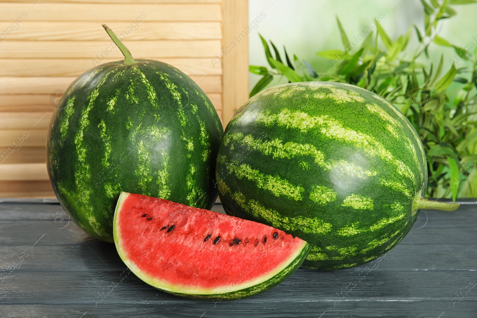 Photo of Fresh juicy watermelon with seeds on wooden table