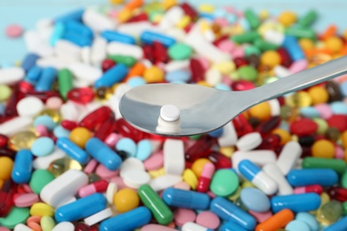 Spoon with weight loss pill over table, closeup