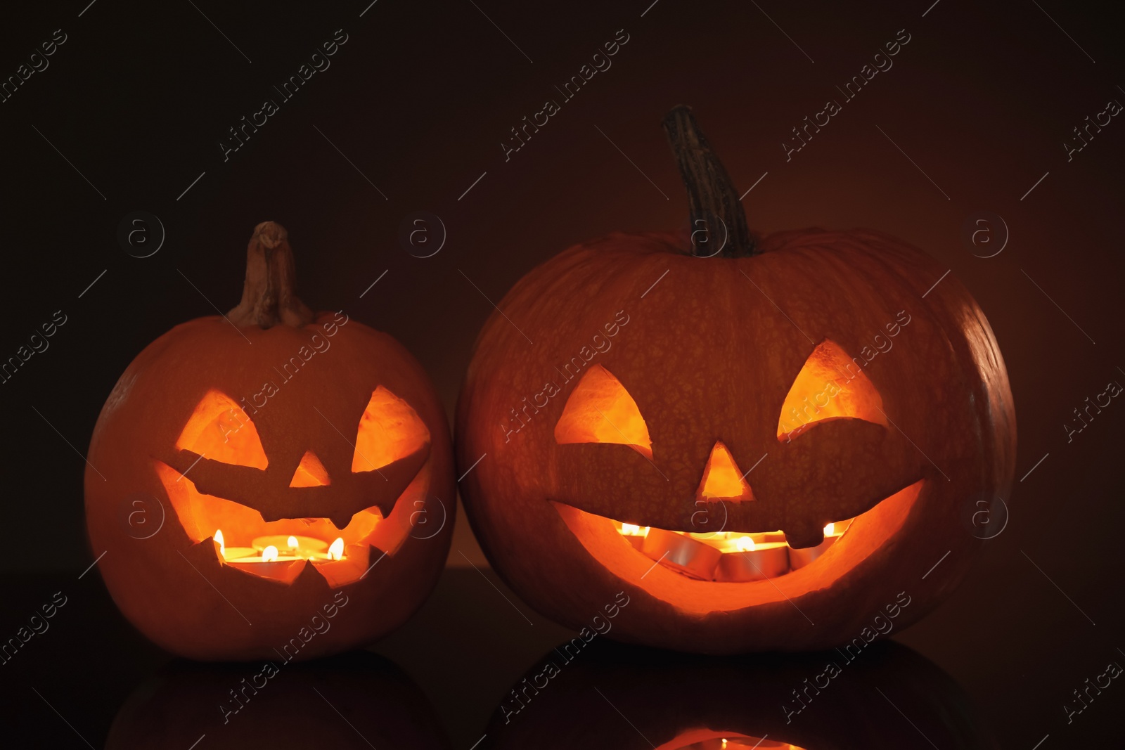 Photo of Halloween pumpkin heads. Glowing jack lanterns in dark