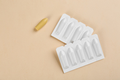 Photo of Suppositories on beige background, flat lay. Hemorrhoid treatment
