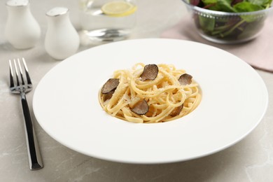 Photo of Delicious pasta with truffle slices and cheese served on light grey table