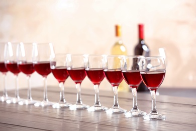 Photo of Glasses with delicious red wine on table