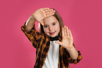 Photo of Cute little girl wearing stylish bandana on pink background