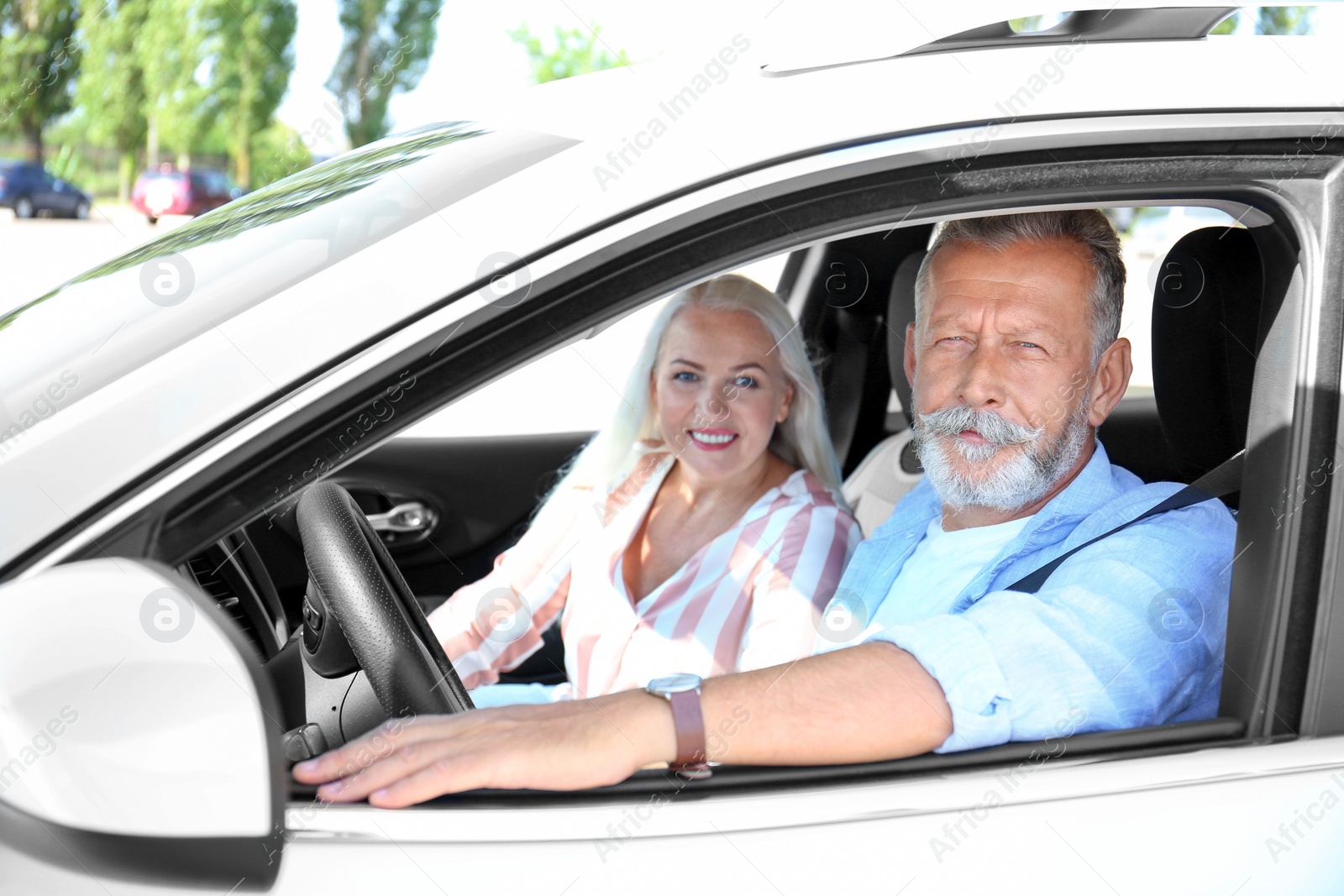 Photo of Happy senior couple travelling together in car