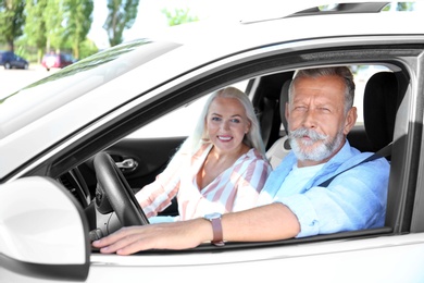 Happy senior couple travelling together in car