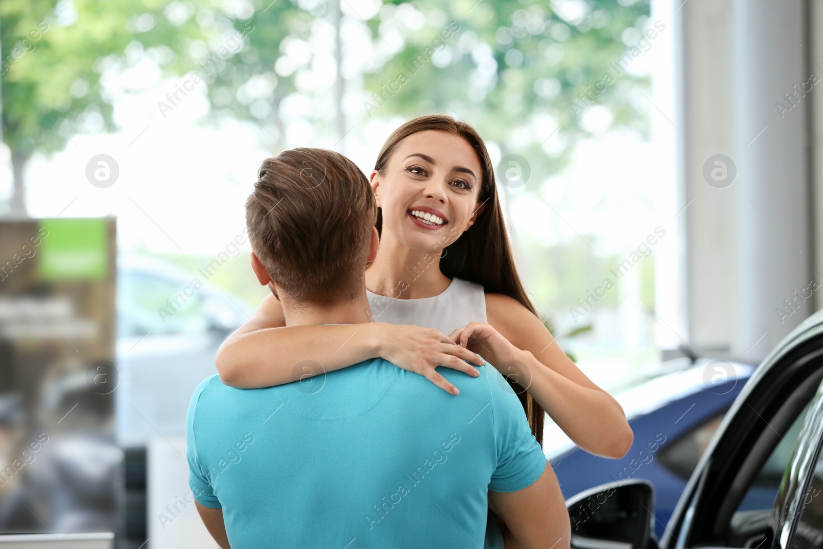 Photo of Happy couple buying new car in salon