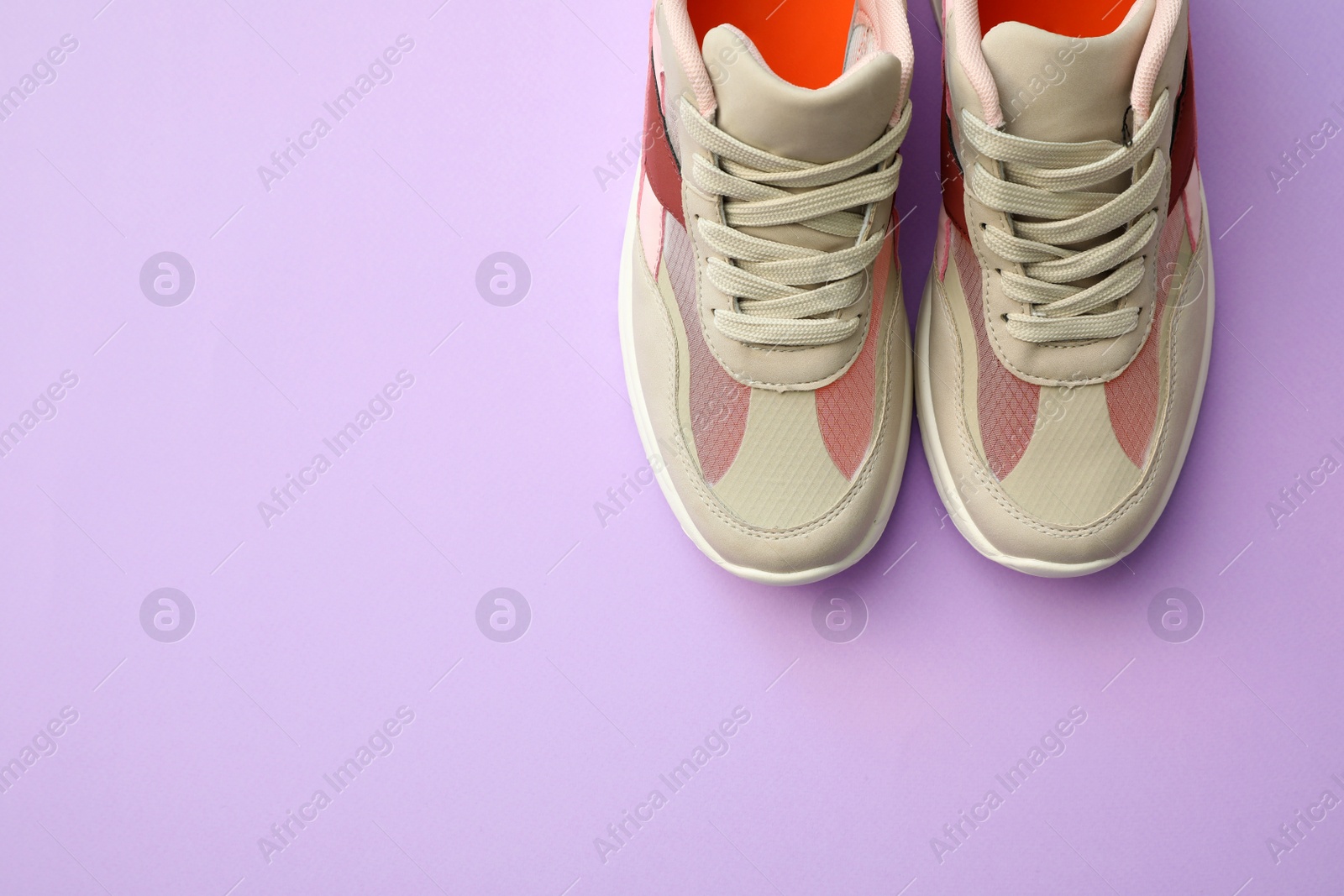 Photo of Pair of stylish shoes on lilac background, top view. Space for text