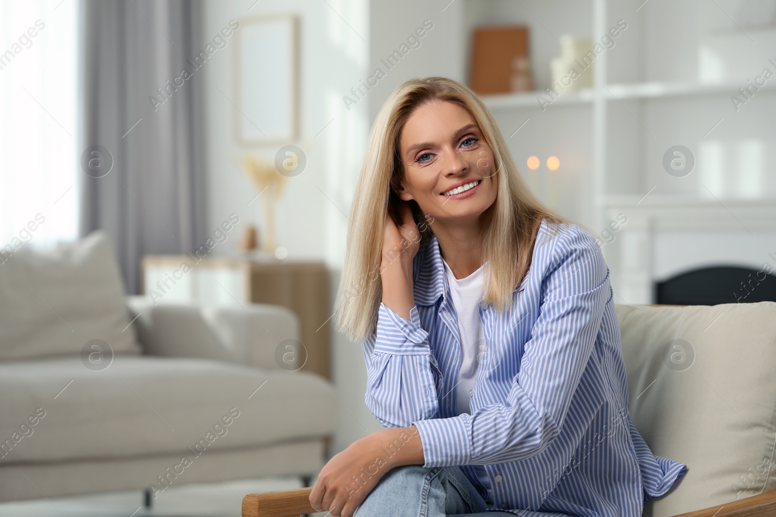 Photo of Portrait of smiling middle aged woman with blonde hair at home. Space for text