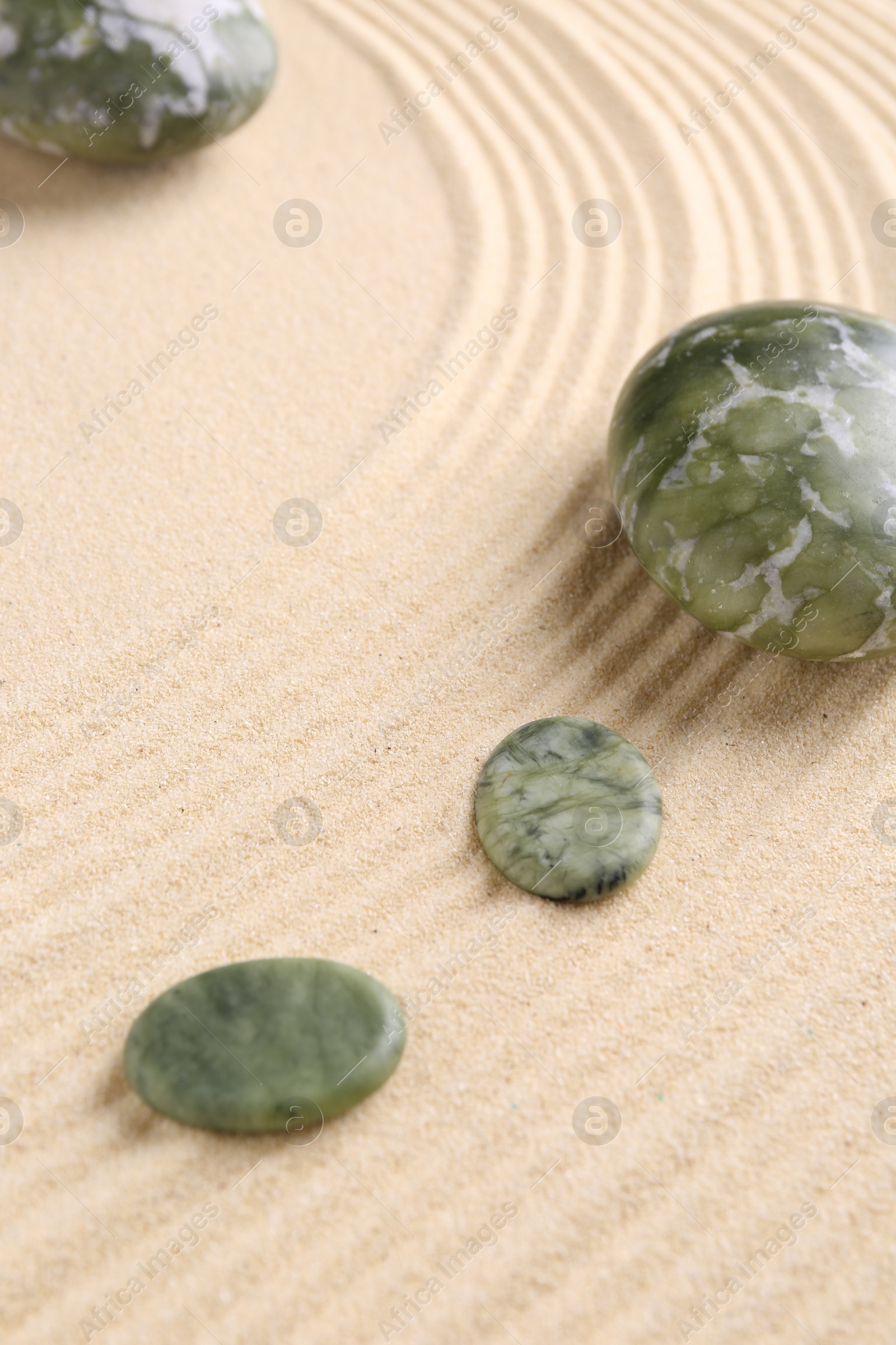 Photo of Zen garden stones on beige sand with pattern