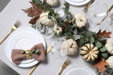 Beautiful autumn table setting. Plates, cutlery, glasses, pumpkins and floral decor, flat lay