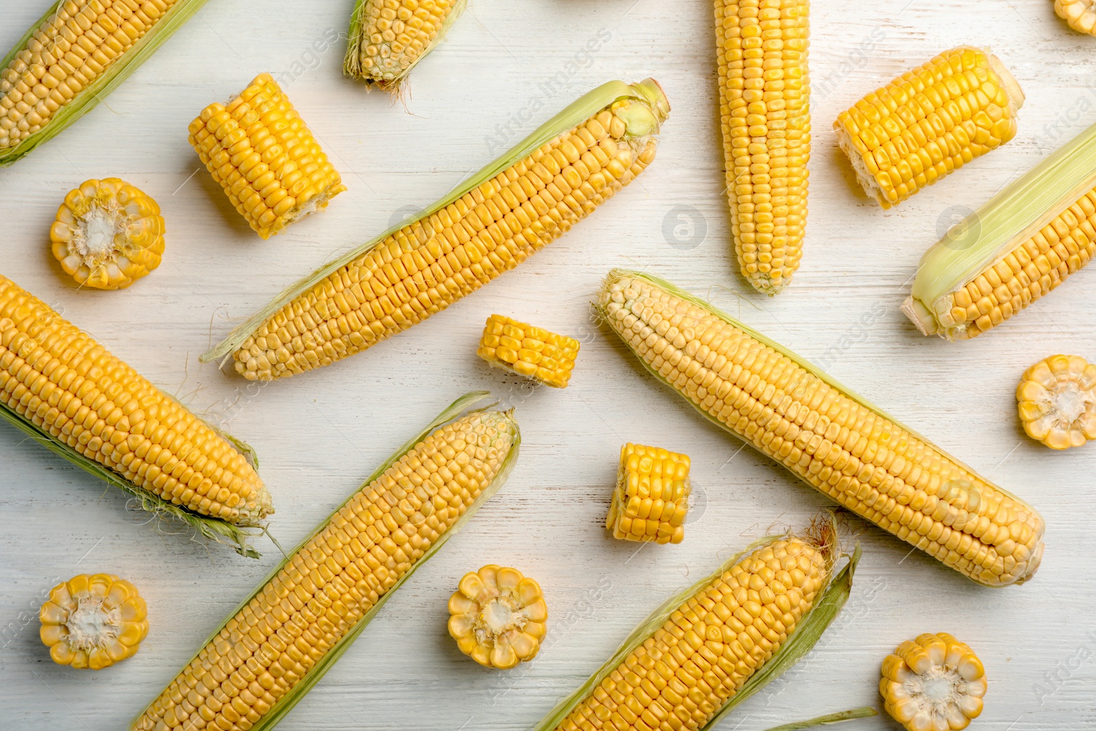 Photo of Flat lay composition with tasty sweet corn cobs on wooden background