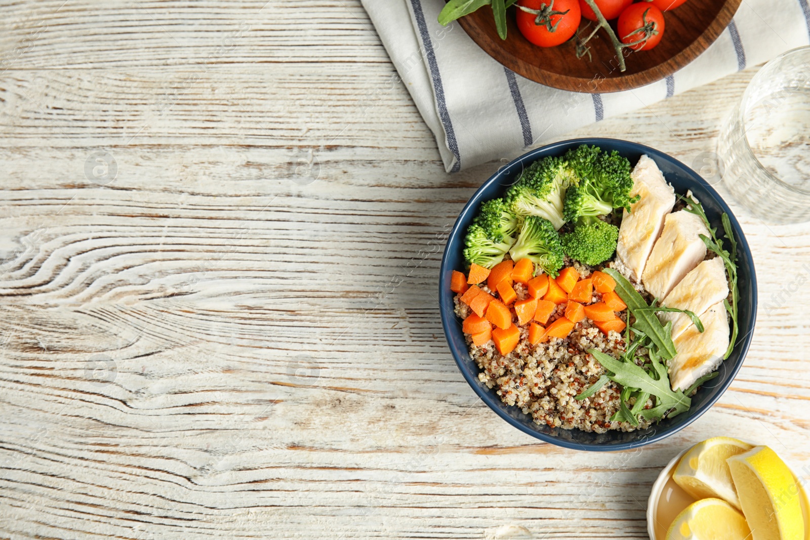 Photo of Ceramic bowl with quinoa and garnish on table, top view. Space for text