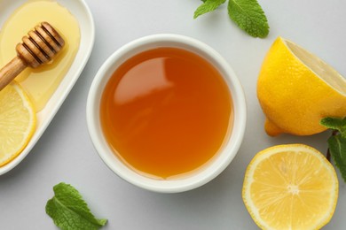 Sweet honey and fresh lemon on white table, flat lay