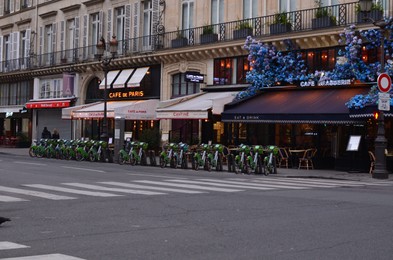 Paris, France - December 10, 2022: Different cafes and bicycle parking on city street