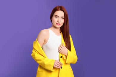 Stylish woman with red dyed hair on purple background