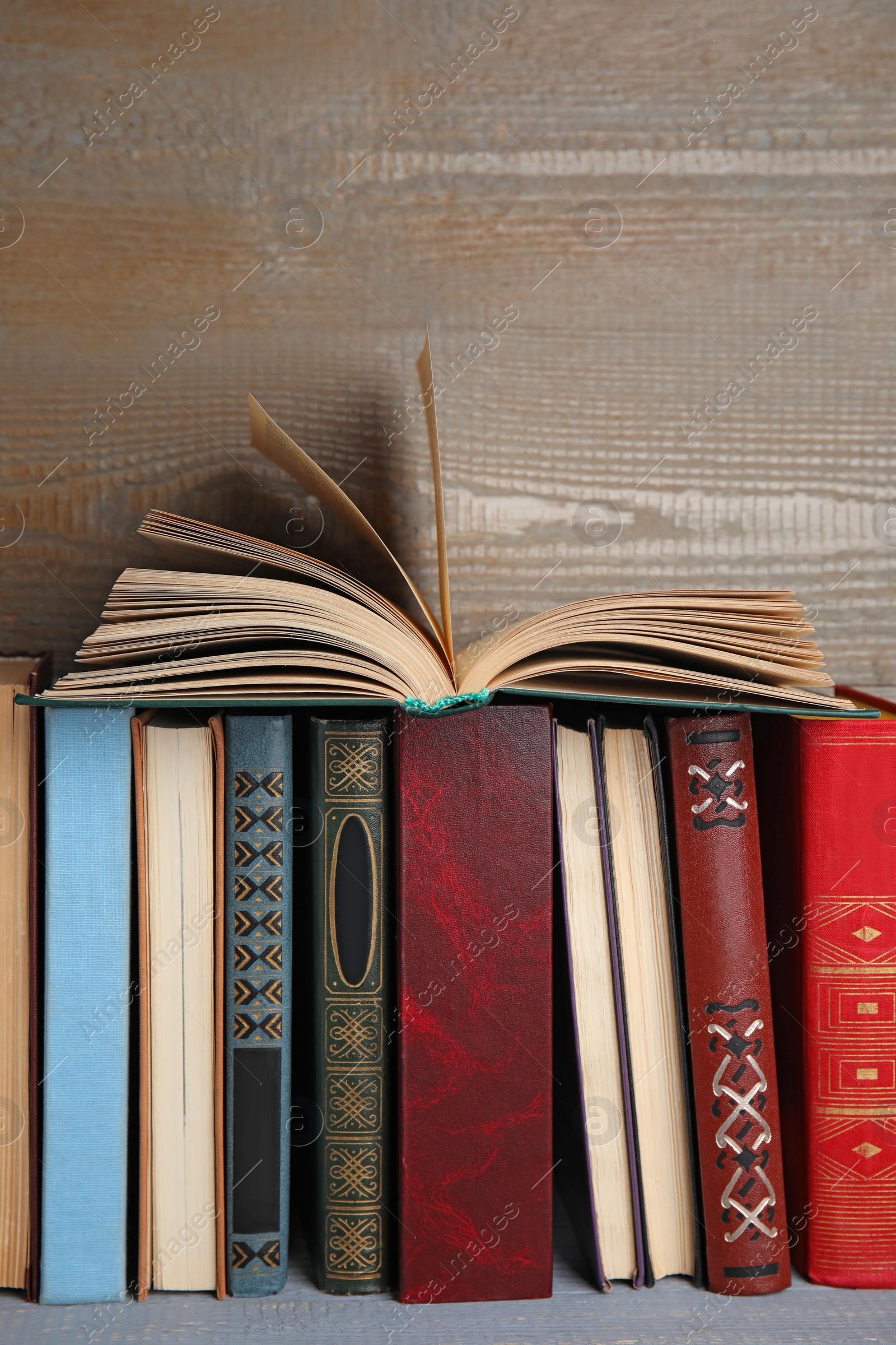 Photo of Different hardcover books on grey wooden table