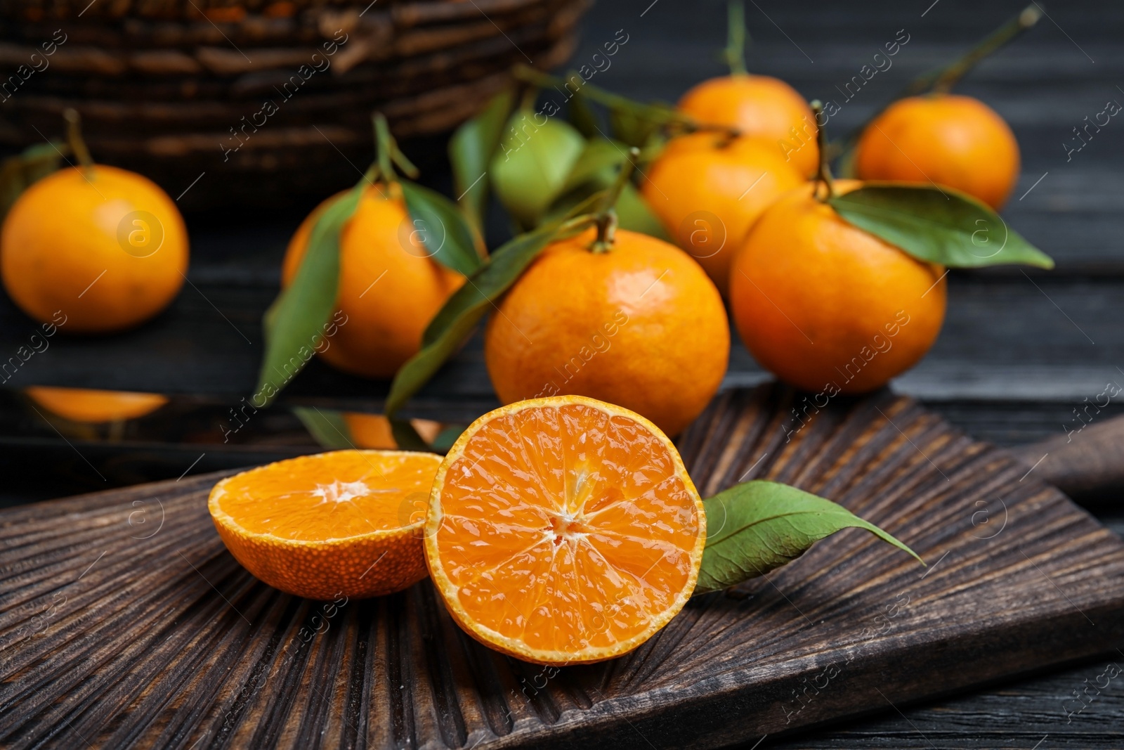 Photo of Fresh juicy cut tangerine on wooden board