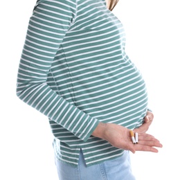 Photo of Young pregnant woman holding broken cigarette on white background, closeup. Harm to unborn baby