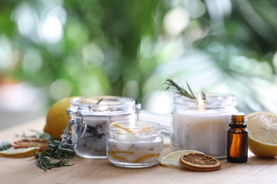 Photo of Natural homemade mosquito repellent candles and ingredients on wooden table outdoors