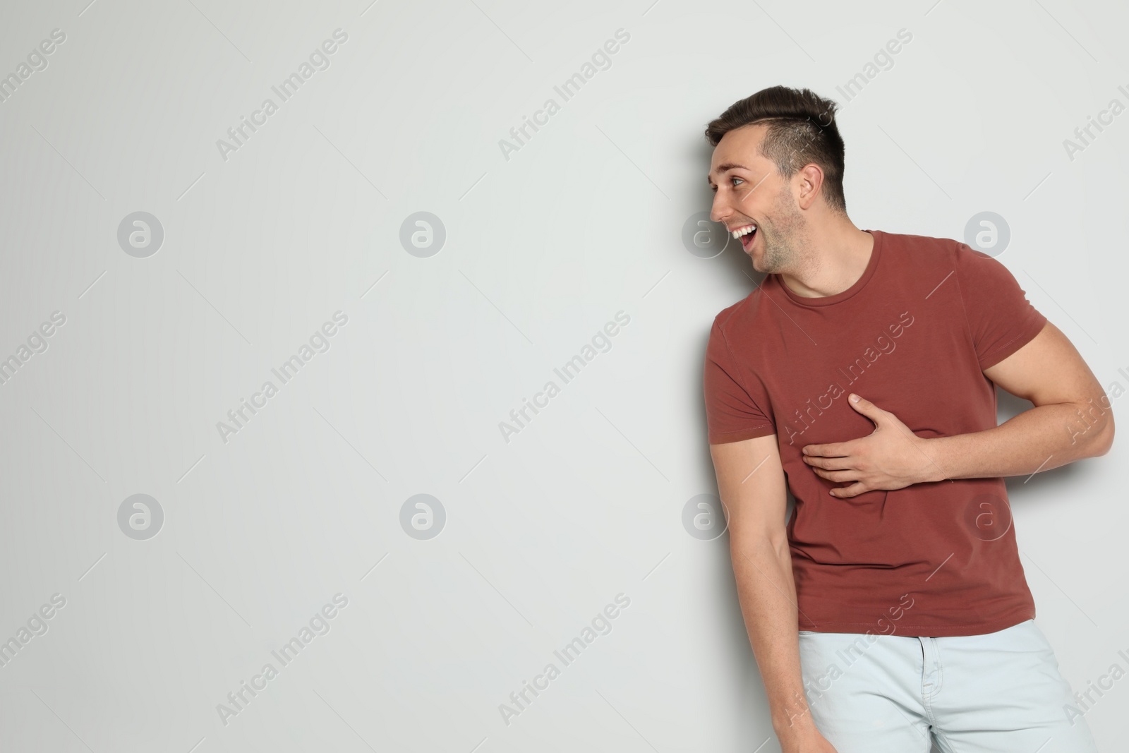 Photo of Portrait of handsome man laughing against light background. Space for text