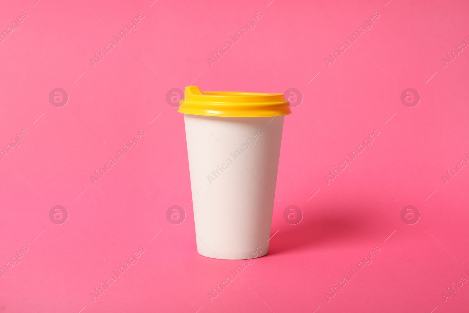 Photo of Takeaway paper coffee cup on pink background