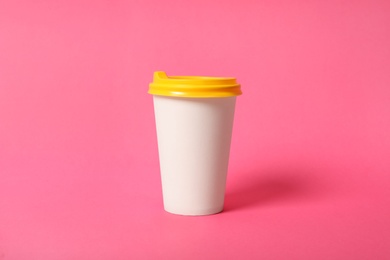 Photo of Takeaway paper coffee cup on pink background