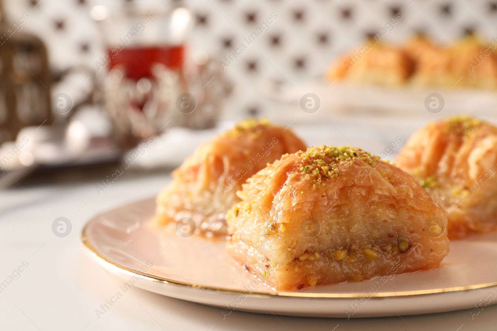 Photo of Delicious sweet baklava with pistachios on white table, closeup