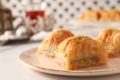 Delicious sweet baklava with pistachios on white table, closeup