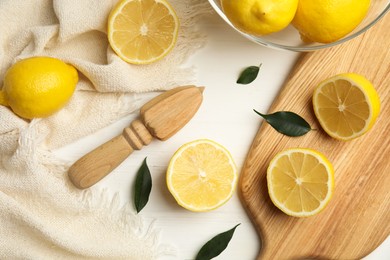 Photo of Citrus reamer and fresh lemons on white wooden table, flat lay