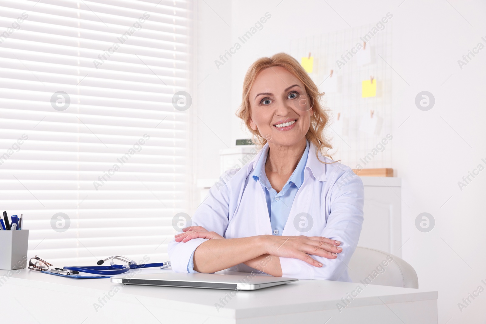 Photo of Doctor with laptop at workplace in clinic. Online medicine concept