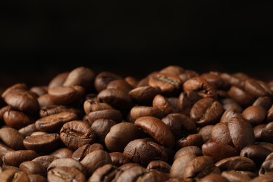 Many roasted coffee beans on black background, closeup