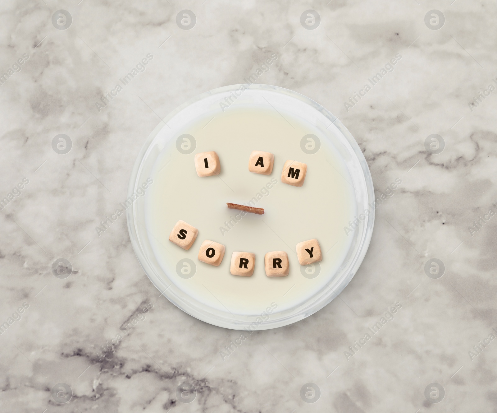 Image of Apology. Phrase I Am Sorry of wooden cubes in candle on white marble table, top view