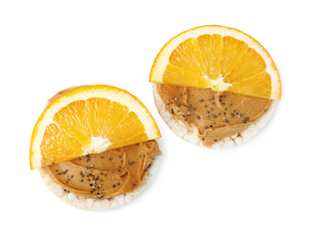 Photo of Puffed rice cakes with peanut butter and orange isolated on white, top view